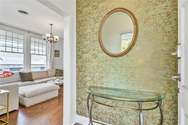 3031 Jena St, New Orleans, LA 70125 - interior space with wallpapered walls, visible vents, wood finished floors, and an inviting chandelier