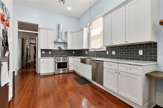 3605 Constance St, New Orleans, LA 70115 - kitchen featuring a sink, wall chimney exhaust hood, stainless steel appliances, light countertops, and dark wood-style floors