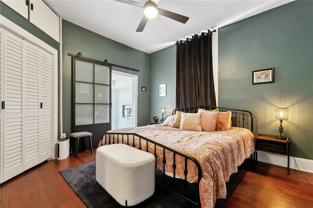 3605 Constance St, New Orleans, LA 70115 - bedroom with ceiling fan, a barn door, baseboards, and dark wood finished floors