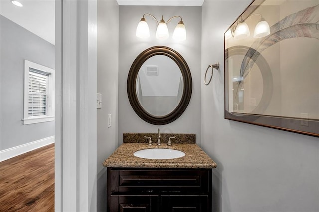bathroom with vanity, baseboards, visible vents, and wood finished floors