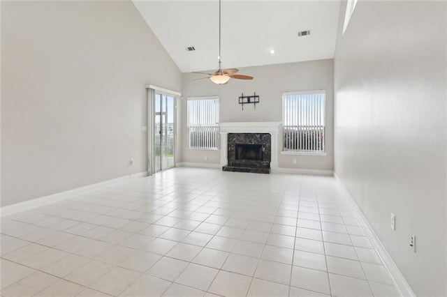 unfurnished living room with light tile patterned floors, visible vents, a premium fireplace, and ceiling fan