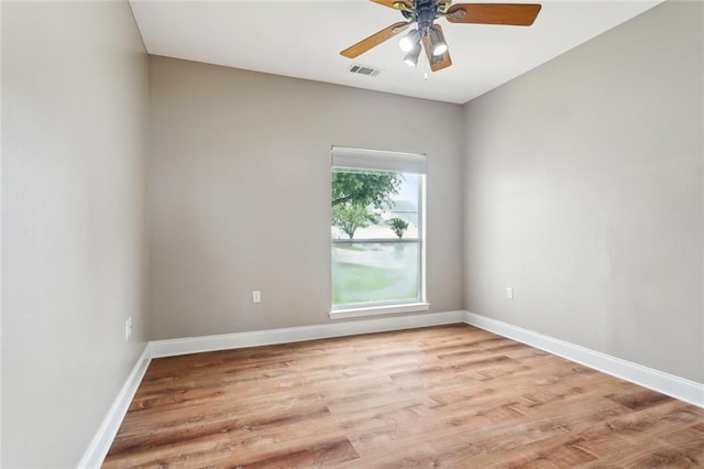 empty room featuring a ceiling fan, baseboards, light wood finished floors, and visible vents