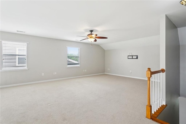 spare room featuring visible vents, baseboards, ceiling fan, light carpet, and lofted ceiling