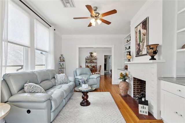 504 N Labarre Rd, Metairie, LA 70001 - living area with a fireplace with flush hearth, crown molding, visible vents, ceiling fan, and light wood-style floors