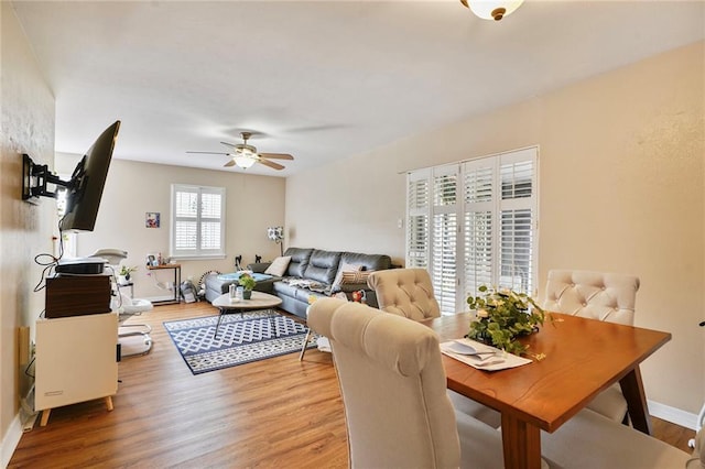 dining area with light wood-style flooring, baseboards, and a ceiling fan