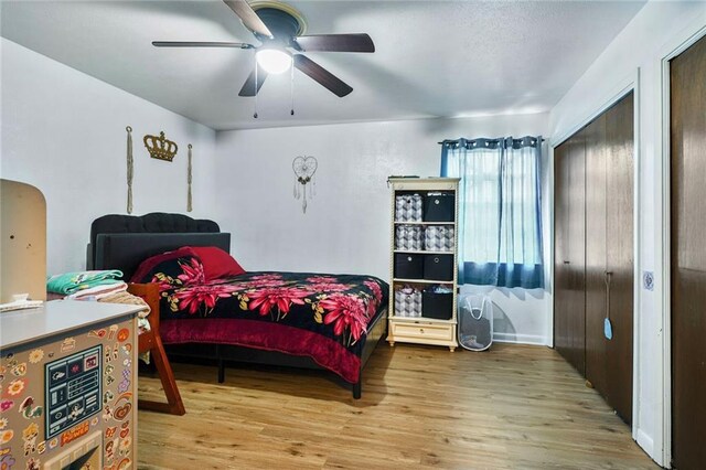 bedroom with wood finished floors, ceiling fan, and arched walkways