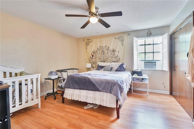bedroom with cooling unit, wood finished floors, baseboards, and ceiling fan