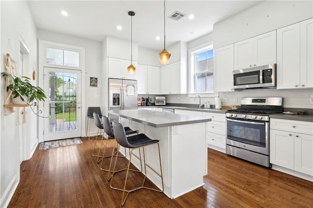 223 S White St, New Orleans, LA 70119 - kitchen with a breakfast bar, a sink, stainless steel appliances, dark wood finished floors, and visible vents