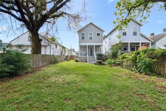 223 S White St, New Orleans, LA 70119 - back of house featuring a lawn, a porch, and a fenced backyard