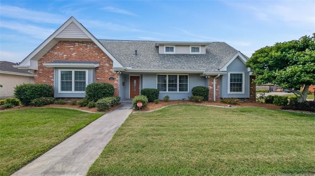view of front of property with brick siding, roof with shingles, stucco siding, and a front yard