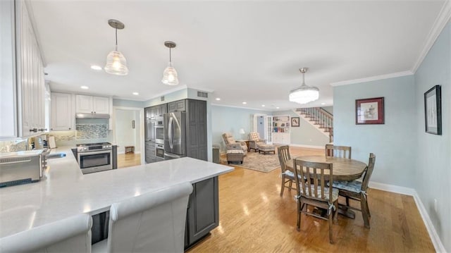 3424 Clifford Dr, Metairie, LA 70002 - kitchen with crown molding, stainless steel appliances, light countertops, and light wood-style flooring