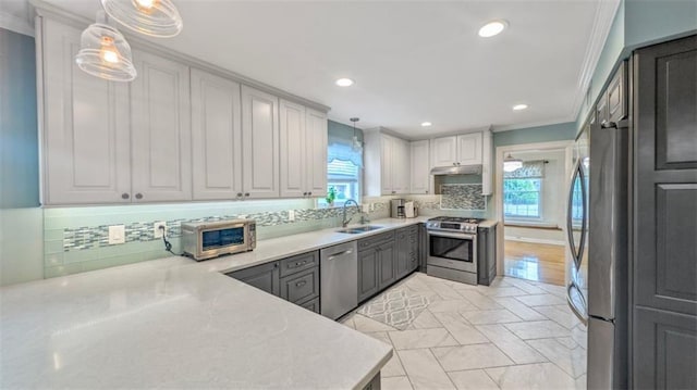 kitchen with crown molding, appliances with stainless steel finishes, a wealth of natural light, and a sink