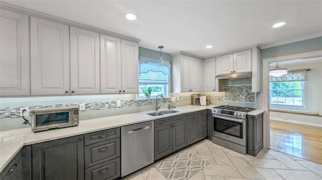 kitchen with a wealth of natural light, appliances with stainless steel finishes, gray cabinets, and a sink