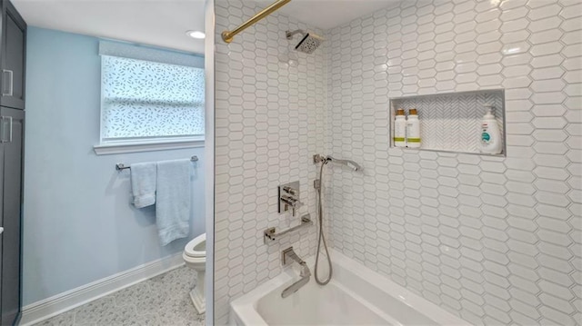 bathroom with toilet, baseboards, and tub / shower combination