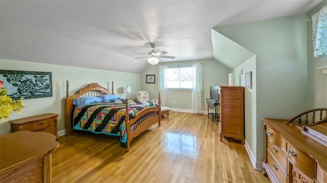 bedroom featuring light wood-style floors, vaulted ceiling, baseboards, and a ceiling fan