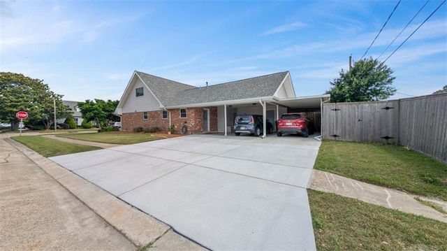 view of side of property with a yard, fence, a carport, and brick siding