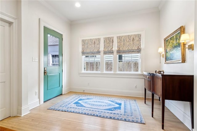 entryway featuring wood finished floors, crown molding, and baseboards