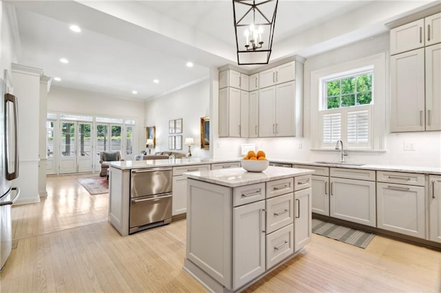 kitchen featuring a sink, light wood-type flooring, plenty of natural light, recessed lighting, and crown molding