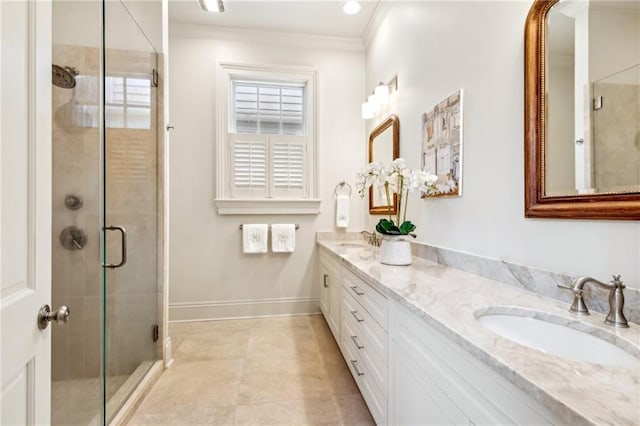full bath featuring a stall shower, ornamental molding, baseboards, double vanity, and tile patterned floors