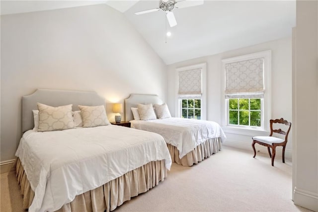 bedroom featuring light carpet, baseboards, a ceiling fan, and high vaulted ceiling