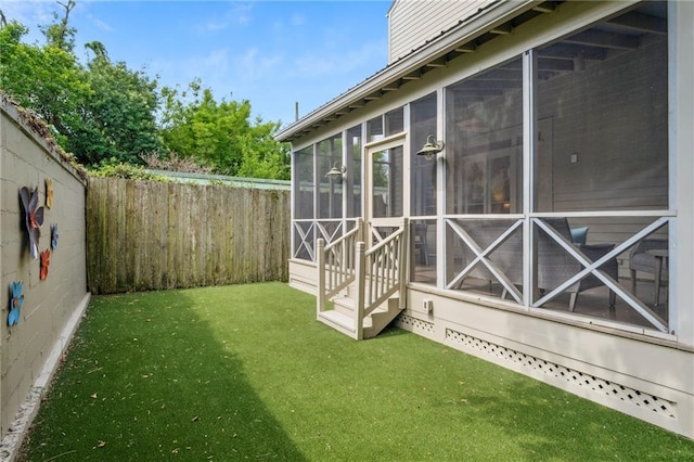 view of yard featuring a sunroom and entry steps