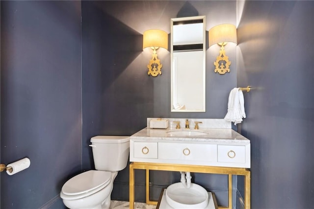 bathroom with vanity, toilet, and baseboards