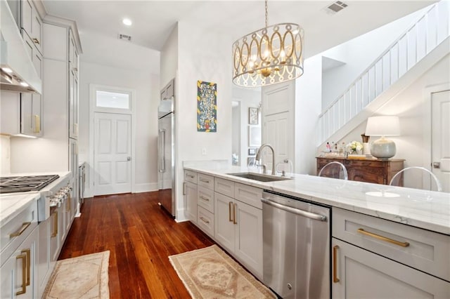 kitchen featuring appliances with stainless steel finishes, visible vents, light stone counters, and a sink