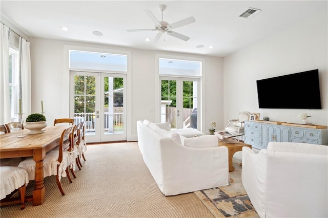 living room with ceiling fan, french doors, plenty of natural light, and visible vents