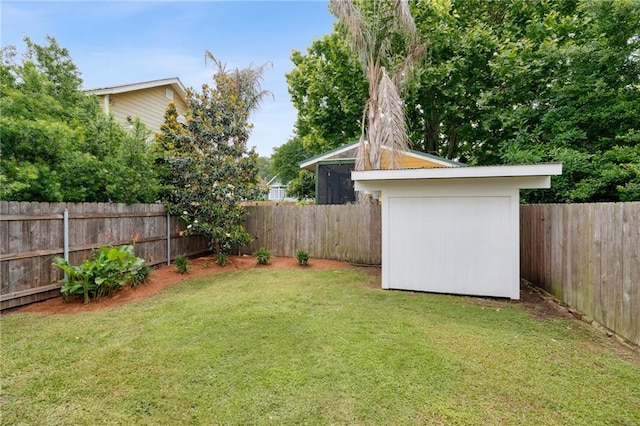 view of yard featuring a fenced backyard, a shed, and an outbuilding