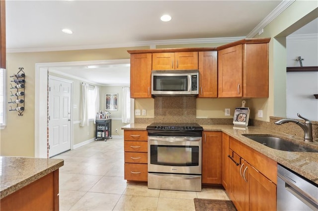 9424 Sharla Dr, River Ridge, LA 70123 - kitchen with brown cabinetry, light stone counters, stainless steel appliances, and a sink