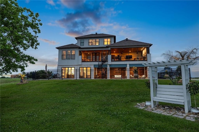 rear view of property featuring a yard, fence private yard, a balcony, and stairway