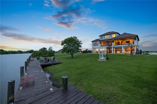 dock area featuring a yard, a water view, and a balcony