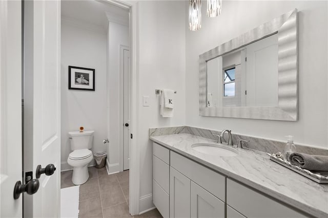 bathroom with toilet, baseboards, tile patterned floors, vanity, and crown molding
