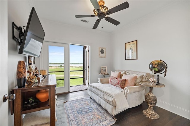 living room featuring ornamental molding, visible vents, wood finished floors, and ceiling fan
