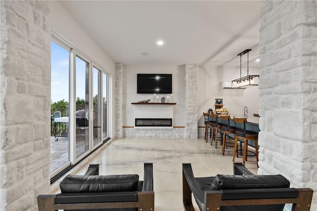 living room with marble finish floor and a glass covered fireplace