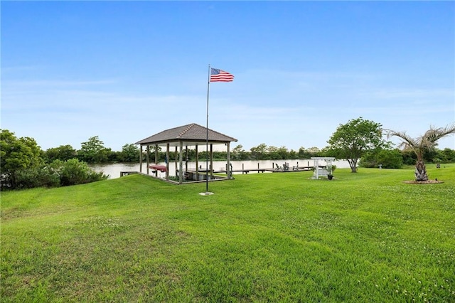 surrounding community with a water view, a gazebo, and a lawn