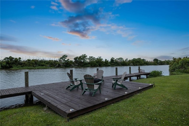 view of dock featuring a lawn and a water view
