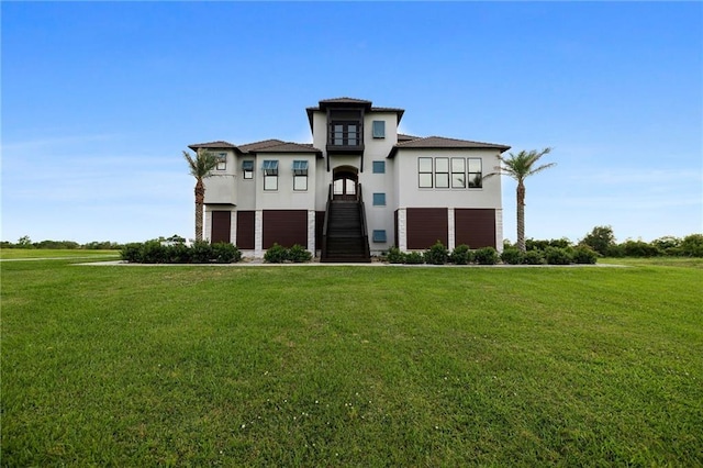 view of front of property with stucco siding, a front yard, and stairs