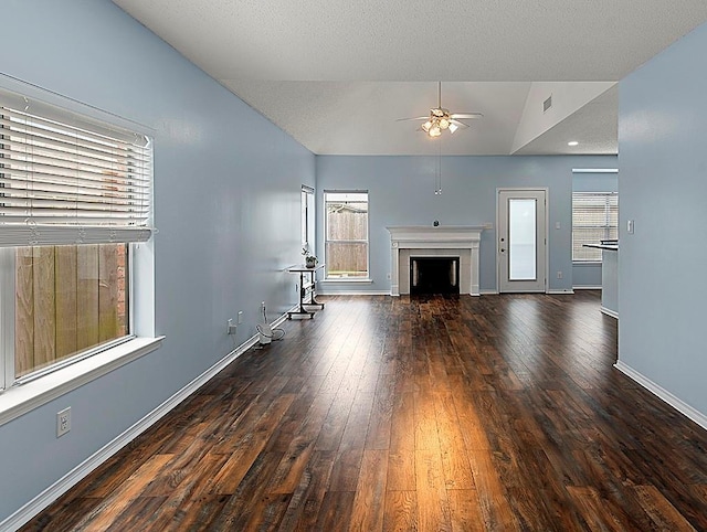 1001 W Chateau Lafitte Dr, Kenner, LA 70065 - unfurnished living room featuring vaulted ceiling, ceiling fan, a fireplace, wood-type flooring, and baseboards