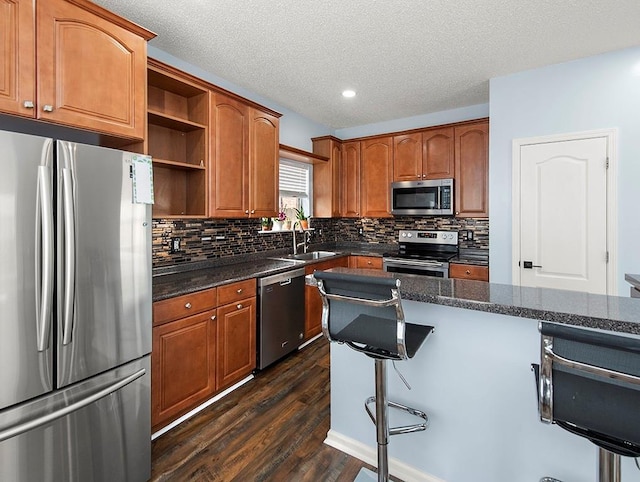1001 W Chateau Lafitte Dr, Kenner, LA 70065 - kitchen featuring stainless steel appliances, open shelves, a sink, dark wood finished floors, and decorative backsplash