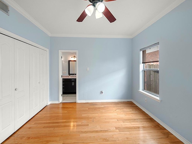 1001 W Chateau Lafitte Dr, Kenner, LA 70065 - unfurnished bedroom with crown molding, a closet, baseboards, light wood-type flooring, and ensuite bathroom