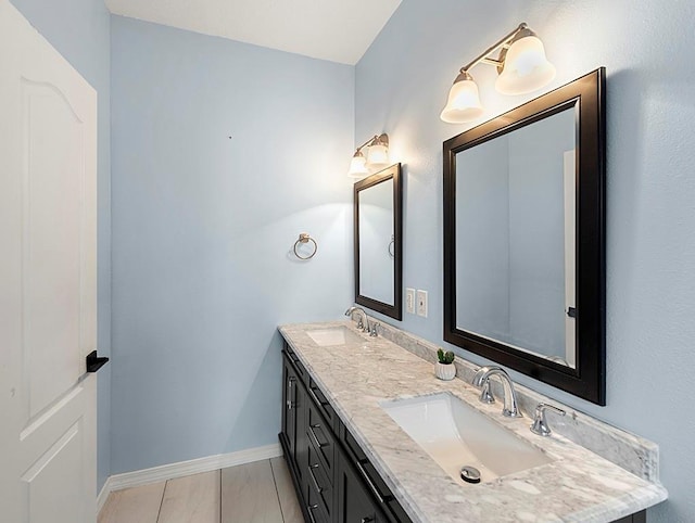 1001 W Chateau Lafitte Dr, Kenner, LA 70065 - bathroom with double vanity, baseboards, and marble finish flooring