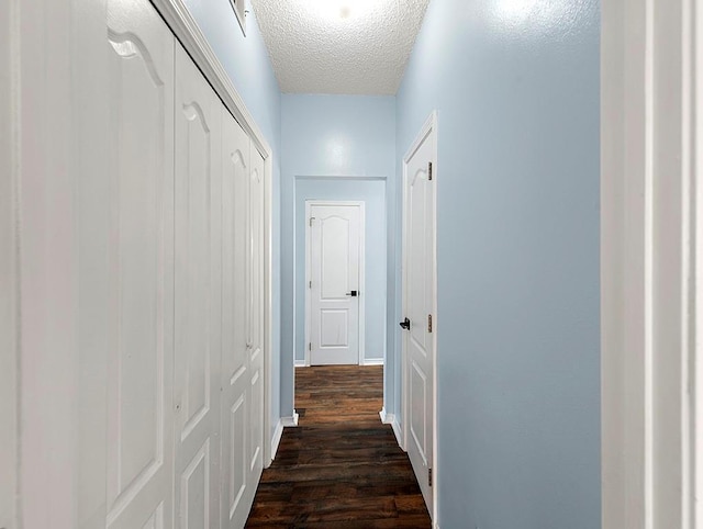 1001 W Chateau Lafitte Dr, Kenner, LA 70065 - hall with a textured ceiling, dark wood finished floors, and baseboards