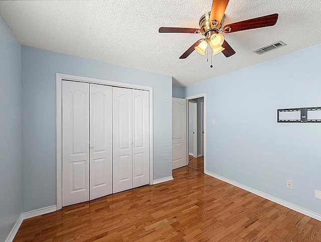 1001 W Chateau Lafitte Dr, Kenner, LA 70065 - unfurnished bedroom featuring wood finished floors, a closet, baseboards, and a textured ceiling