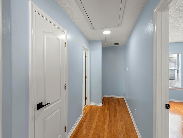 1001 W Chateau Lafitte Dr, Kenner, LA 70065 - hall featuring attic access, light wood-type flooring, and baseboards