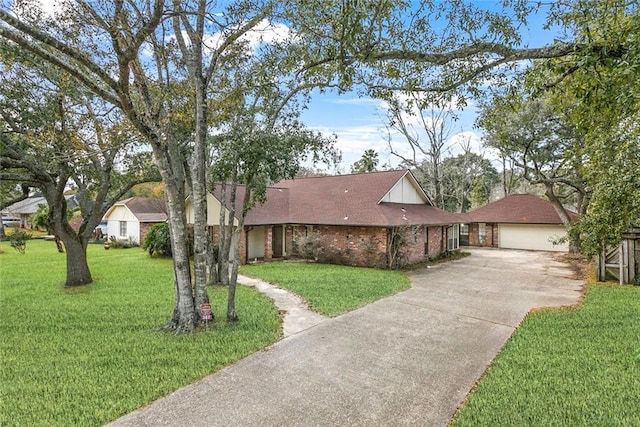 view of front of house with a front lawn, brick siding, roof with shingles, and a detached garage