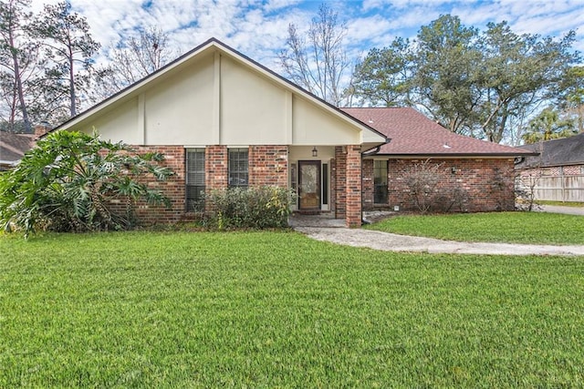 ranch-style home featuring fence, brick siding, and a front yard