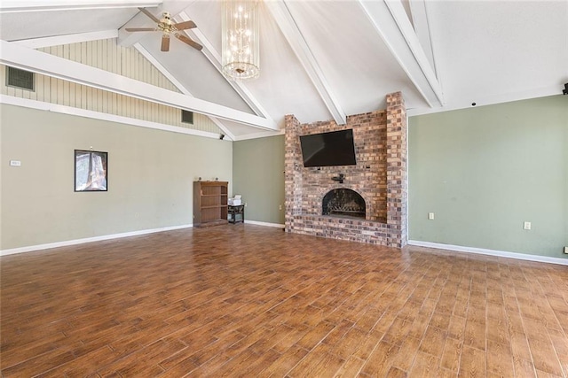 unfurnished living room with a fireplace, beamed ceiling, a ceiling fan, and wood finished floors