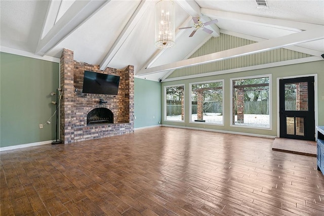 unfurnished living room featuring wood finished floors, lofted ceiling with beams, a brick fireplace, baseboards, and ceiling fan