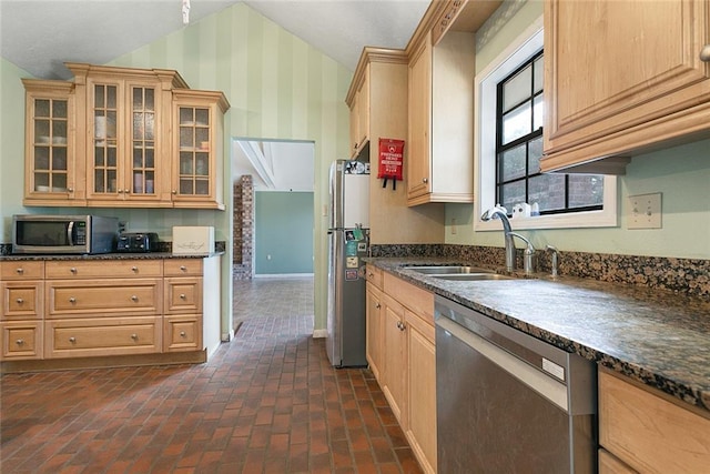 kitchen featuring wallpapered walls, brick floor, baseboards, a sink, and stainless steel appliances